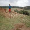 Detail of erosion to SW side of cairn; Mrs Angela Gannon (RCAHMS) in picture
