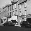 General view of 63, 67 and 69 High Street, Dunbar, from S including St George Hotel, George Low and Son, a chemist and George Hurry tea room.