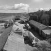 Elevated view from W (at middle level of shaft kilns) of E end of site, including workshops and offices, with old lime kiln (distant right, NO30NE 23.3)