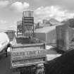 View from W of W end of lime works, showing road haulage vehicles in foreground, and dispatch hoppers in background