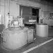 Motherwell, Craigneuk Street, Anderson Boyes
Heat Treatment (Dept. 12, west bay built 1945): Interior view from north west in the west bay of one of three Wild Barfield Carbo-drip heating furnaces, and cooling pot (right).  The furnace is fuelled by clean endothermic gas (produced by a generator on the other side of the bay), and heat treatment is required for the hardening of components of machines, such as gears.