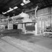 Motherwell, Craigneuk Street, Anderson Boyes
Heat Treatment (Dept. 12, east bay, built 1981): Interior view from SW showing two Gibbons Heating Ovens (fired by ordinary natural gas), separated by an oil quenching tank.  Note that the furnaces are loaded and unloaded using a rail-mounted traverser.