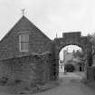 View of stable block through entrance arch to East