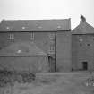 View of mill from E, prior to removal of building on E of mill.