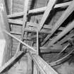 Interior
View of roof space, showing part of vertical line-shaft and flat-belt pulley (with gears above), and adjacent bucket elevators and chute (foreground).