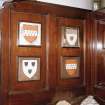 Ground floor, library, right side, fireplace panelled surround, heraldic shields, detail