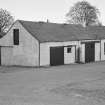 View of 1 and 3 Church Road, Kirkpatrick Durham, from north, showing Mansefield and a garage with a shell pump outside