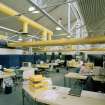 Interior view of office area, within which yellow in/out trays match overhead ducts.
