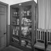 Vestry, cupboard containing chalices, pewter and silver ware and books, detail