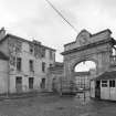 View of courtyard buildings and 'clock' entrance arch from NW