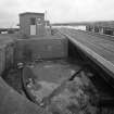 Kirkcaldy Harbour
View from north of east side of railway swing bridge, showing rail and chain guiding the rotation of the bridge (within circular recessed concrete turning space), with control booth in background.  Most of the bridge is visible (right), having been left in the closed position, leaving the channel open to shipping