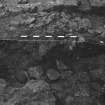 Excavation photograph : area F - half section, W facing through pit 75, with rubble fill 34.