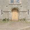 Entrance front, main door flanked on either side by narrow round arched windows, detail