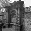 View of funerary monument on West wall of churchyard.