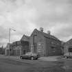 View from E of central block containing Engine and Boiler Houses (with neighbouring houses just visible to left).