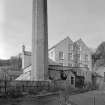 View of main building and engine house with chimneystack, Bongate Mill, Jedburgh, from east