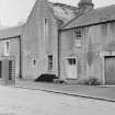 View of houses on Main Street, Abernethy, including a thatched roofed cottage in state of disrepair. Demolished 1966.
