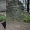 View of headstone 1711 to Patrick Wear, weaver, with primitive head and cross bones, and initials P W, Arbroath Abbey Churchyard.