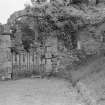 View of garden wall with arched gateway and inscribed stone, Woodhouselee.
