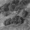 Oblique aerial view centred on the remains of St Blane's Church and burial ground, Bute, taken from the SE.