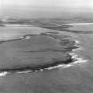 Oblique aerial view centred on the chambered cairn (south) on Holm of Papa Westray with Papa Westray visible in the distance.