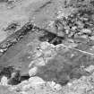 Excavation photograph showing entrance way, post holes and timber 'floor'

