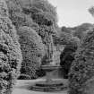 View of fountain and surrounding shrubbery in garden of Ravelston House, Edinburgh.
