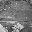 Edinburgh Castle, settlement. Excavation photograph showing area H - SE corner of area, possible stone revetting feature with cobbling 310 to S, and midden 300 to N.