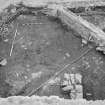 Edinburgh Castle, settlement. Excavation photograph showing area H - SE corner of area, stone revetting?. feature with cobbling 310 to S, and midden 300 to N.