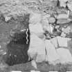 Edinburgh Castle, settlement. Excavation photograph showing area H - half sectioned (W facing section) of slag pit - 318 stone lining visible.