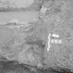 Edinburgh Castle, settlement. Excavation photograph: area H - remains of half sectioned cut, poss feeding trough to E.