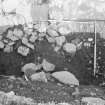 Edinburgh Castle, settlement. Excavation photograph: area H - jumble of stones overlying 497 'peat' and patch of burnt peat 532.