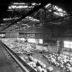 Interior.
View of overhead gantry crane loading steel coils onto lorry in despatch area.