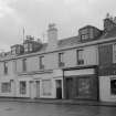 View of 57-61 Glasgow Street, Ardrossan, from SE, showing the premises of R McCutcheon, Mary Muir, Stewart & Murray and A Lothian.