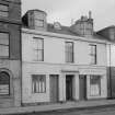 View of 5-7 Princes Street, Ardrossan, from SW, showing a general store and cycle shop.