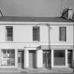 View of 13-17 Princes Street, Ardrossan, from SW, showing the premises of M Monaghan.