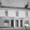View of 31-35 Princes Street, Ardrossan, from SW, showing Seamus Gents Hairdresser and a general store.