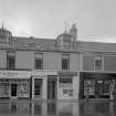 View of 47-53 Princes Street, Ardrossan, from SW, showing the premises of Cockburns dispensing chemist, Ministry of Labour and J N Macdonald & Co.