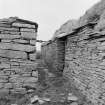 View of passage between dwelling and farm building from N.