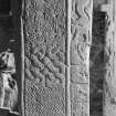 View of face A of cross-slab at Ardchattan, showing shaft of cross, and animals, musicians and warrior on the right of the cross-shaft.
 
