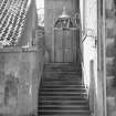 View from E of stairs up to entrance doorway.