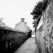 View from east of wall enclosing Cardy Net Works and rear of Cardy Cottage