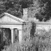 General view of delapidated overgrown lodge.