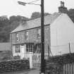 Oblique view of unidentified 2-storey cottage with glass porch