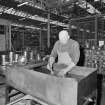 Glasgow, Springburn, St Rollox Locomotive Works, interior.
View of man working at carriage roller bearing cleaning tub.