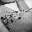 Oblique aerial view centred on church from NE.