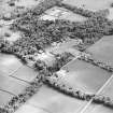 Oblique aerial view centred on the farmsteading, kennels and cottage with country house and formal garden adjacent, taken from the N