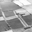 Oblique aerial view centred on the farmsteading, farmhouse and cottage, taken from the NNW