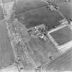 Oblique aerial view centred on the farmhouse and steading with the remains of the plantation adjacent, taken from the WSW