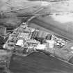Oblique aerial view centred on the paper mill with the house and office adjacent, taken from the NW.